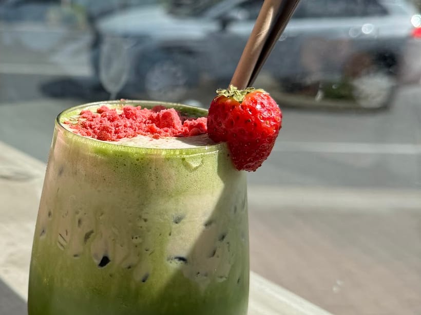 Iced matcha topped with a fresh strawberry