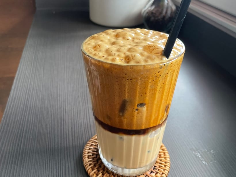 An iced latte on a rattan coaster