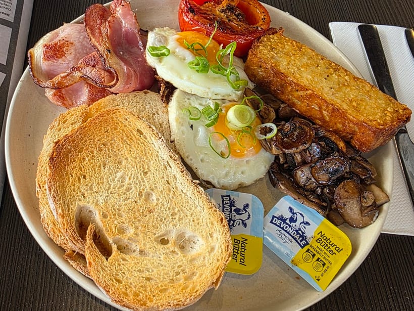 A big breakfast plate with eggs, bacon, hash brown and toast